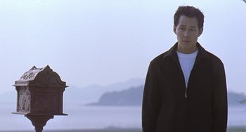 Movie still from “Il Mare” (2000), directed by Hyun-seung Lee – A man standing in front of a fire hydrant; Medium shot, Low angle