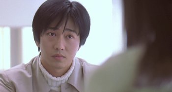 Movie still from “Il Mare” (2000), directed by Hyun-seung Lee – A man with short black hair wearing a white shirt; Close Up shot, Over the shoulder angle