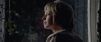 Movie still from “Images” (1972), directed by Robert Altman – A woman is looking out a window at night; Close Up shot, Low angle