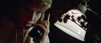 Movie still from “Images” (1972), directed by Robert Altman – A woman talking on a phone in a dark room; Close Up shot, Low angle