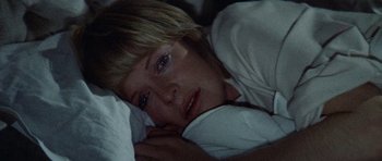 Movie still from “Images” (1972), directed by Robert Altman – A woman laying in bed with her head on a pillow; Close Up shot, High angle