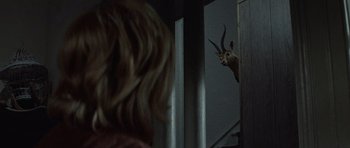 Movie still from “Images” (1972), directed by Robert Altman – A woman looking into a mirror with an animal on it's head; Medium shot, Over the shoulder angle