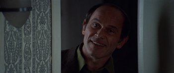 Movie still from “Images” (1972), directed by Robert Altman – A man smiling in front of a mirror; Close Up shot, Over the shoulder angle