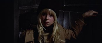 Movie still from “Images” (1972), directed by Robert Altman – A woman with long blonde hair wearing a black hat; Close Up shot, Low angle