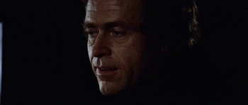 Movie still from “Images” (1972), directed by Robert Altman – A man's face in the dark; Close Up shot, Low angle