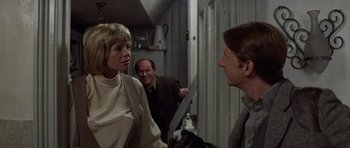 Movie still from “Images” (1972), directed by Robert Altman – Two men and a woman talking in a room; Medium shot, Over the shoulder angle