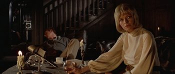 Movie still from “Images” (1972), directed by Robert Altman – A man and a woman sitting at a table with a candle; Medium shot, Low angle