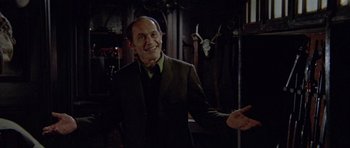 Movie still from “Images” (1972), directed by Robert Altman – An older man in a suit smiling for the camera; Medium shot, Low angle