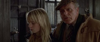An older man and a young girl sitting next to each other