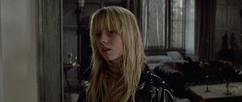Movie still from “Images” (1972), directed by Robert Altman – A woman with long blonde hair wearing a leather jacket; Close Up shot, Over the shoulder angle
