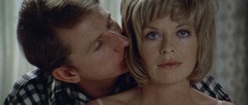 Movie still from “Images” (1972), directed by Robert Altman – A man kissing a woman on the cheek in front of a mirror; Close Up shot, Low angle