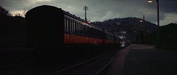 Movie still from “Images” (1972), directed by Robert Altman – A train traveling down train tracks next to a forest; Extreme Wide shot, High angle