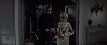 Movie still from “Images” (1972), directed by Robert Altman – A man and a woman standing next to each other in a room; Medium shot, Over the shoulder angle