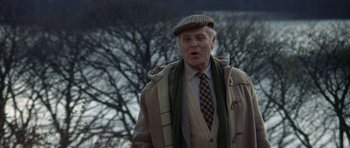 Movie still from “Images” (1972), directed by Robert Altman – An older man wearing a coat and a tie; Medium shot, Low angle