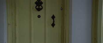 Movie still from “Images” (1972), directed by Robert Altman – The door handle and knob of a yellow door; Extreme Close Up shot, Overhead angle