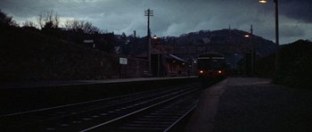 Movie still from “Images” (1972), directed by Robert Altman – A train on the tracks near a train station at night; Extreme Wide shot, High angle