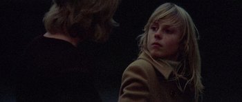 Movie still from “Images” (1972), directed by Robert Altman – A young girl in a brown coat is looking at a man; Close Up shot, Over the shoulder angle