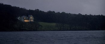 Movie still from “Images” (1972), directed by Robert Altman – A house on the side of a hill near a body of water; Extreme Wide shot, Low angle