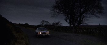 Movie still from “Images” (1972), directed by Robert Altman – A car driving down a road at night; Extreme Wide shot, Low angle