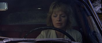 Movie still from “Images” (1972), directed by Robert Altman – A woman sitting in the driver's seat of a car; Close Up shot, Low angle