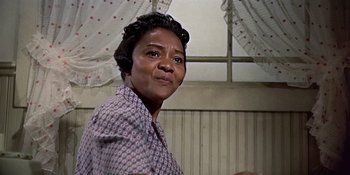 Movie still from “Imitation of Life” (1959), directed by Douglas Sirk – An older woman standing in front of a window; Close Up shot, Low angle