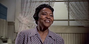 Movie still from “Imitation of Life” (1959), directed by Douglas Sirk – An older black woman smiling for the camera; Close Up shot, Low angle
