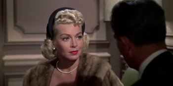 Movie still from “Imitation of Life” (1959), directed by Douglas Sirk – A woman in a fur coat with a pearl necklace; Close Up shot, Over the shoulder angle