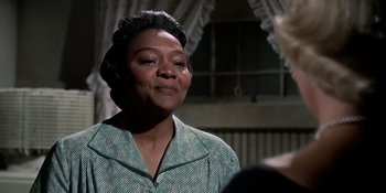 Movie still from “Imitation of Life” (1959), directed by Douglas Sirk – An older woman in a green and white checkered shirt; Close Up shot, Over the shoulder angle