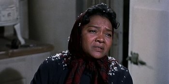 Movie still from “Imitation of Life” (1959), directed by Douglas Sirk – An older black woman wearing a red and black scarf; Close Up shot, Low angle