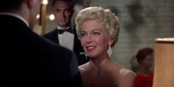 Movie still from “Imitation of Life” (1959), directed by Douglas Sirk – An older woman in a strapless dress and a tuxedo; Close Up shot, Over the shoulder angle