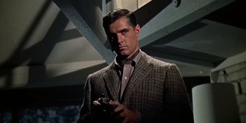 Movie still from “Imitation of Life” (1959), directed by Douglas Sirk – A man holding a cell phone while wearing a suit and tie; Close Up shot, Low angle
