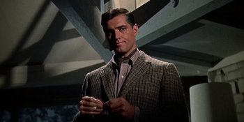 Movie still from “Imitation of Life” (1959), directed by Douglas Sirk – A man wearing a suit and tie in a room; Close Up shot, Low angle
