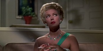 Movie still from “Imitation of Life” (1959), directed by Douglas Sirk – A woman in a green dress smoking a cigarette; Close Up shot, Low angle
