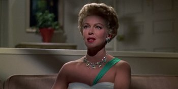 Movie still from “Imitation of Life” (1959), directed by Douglas Sirk – An older woman wearing a white dress and a green ribbon; Close Up shot, Low angle