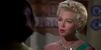Movie still from “Imitation of Life” (1959), directed by Douglas Sirk – A woman wearing a diamond necklace and a diamond necklace; Close Up shot, Over the shoulder angle