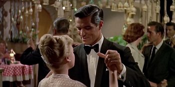 Movie still from “Imitation of Life” (1959), directed by Douglas Sirk – A man in a tuxedo dancing with a woman in a black dress; Medium shot, Low angle