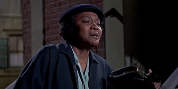 Movie still from “Imitation of Life” (1959), directed by Douglas Sirk – An older black woman wearing a black hat; Close Up shot, Low angle