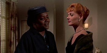 Movie still from “Imitation of Life” (1959), directed by Douglas Sirk – Two women standing next to each other and one of them is wearing a hat; Close Up shot, Low angle