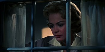 Movie still from “Imitation of Life” (1959), directed by Douglas Sirk – A woman looking through the bars of a jail cell; Close Up shot, Low angle