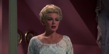 Movie still from “Imitation of Life” (1959), directed by Douglas Sirk – A woman with blonde hair wearing a white dress; Close Up shot, Low angle