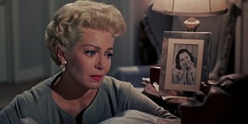 Movie still from “Imitation of Life” (1959), directed by Douglas Sirk – An older woman sitting in front of a mirror; Close Up shot, Over the shoulder angle