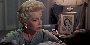 Movie still from “Imitation of Life” (1959), directed by Douglas Sirk – An older woman sitting in front of a picture; Close Up shot, Over the shoulder angle