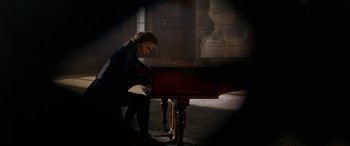 Movie still from “Immortal Beloved” (1994), directed by Bernard Rose – A man sitting at a piano in a room; Medium shot, High angle
