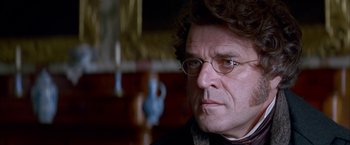 Movie still from “Immortal Beloved” (1994), directed by Bernard Rose – A person wearing glasses; Close Up shot, Over the shoulder angle