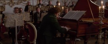 Movie still from “Immortal Beloved” (1994), directed by Bernard Rose – A person playing a piano in front of a group of people; Medium shot, High angle