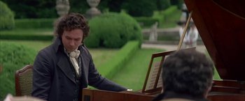 Movie still from “Immortal Beloved” (1994), directed by Bernard Rose – A man playing a piano in a garden setting; Medium shot, Over the shoulder angle