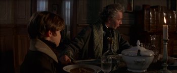 Movie still from “Immortal Beloved” (1994), directed by Bernard Rose – A man sitting at a dinner table with a child; Medium shot, Over the shoulder angle
