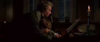 A man and a boy are looking at a book