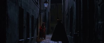 Movie still from “Immortal Beloved” (1994), directed by Bernard Rose – A woman in a red dress and a man in a black suit are in a dark alley; Wide shot, High angle
