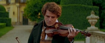Movie still from “Immortal Beloved” (1994), directed by Bernard Rose – A man holding a violin while standing in a park; Close Up shot, Over the shoulder angle